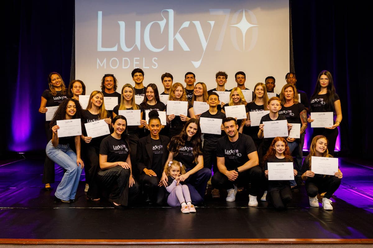 Turma do Workshop Modelo Profissional Lucky70 2026 no palco do Teatro do CESCB, em Brusque, com os certificados